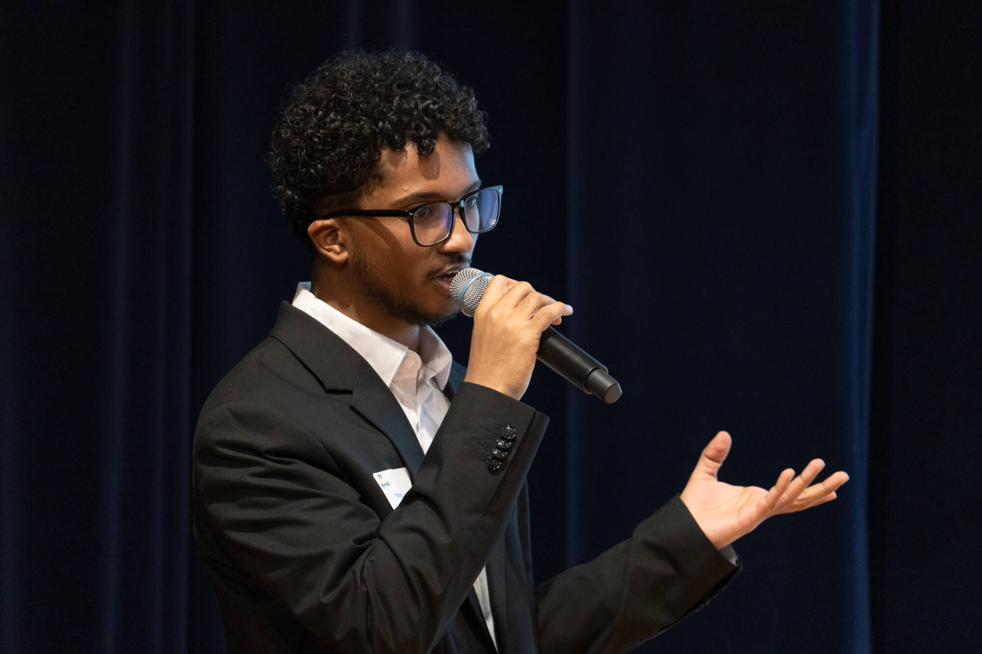 Student talking into a microphone at a recent 77 Idea Quest event.